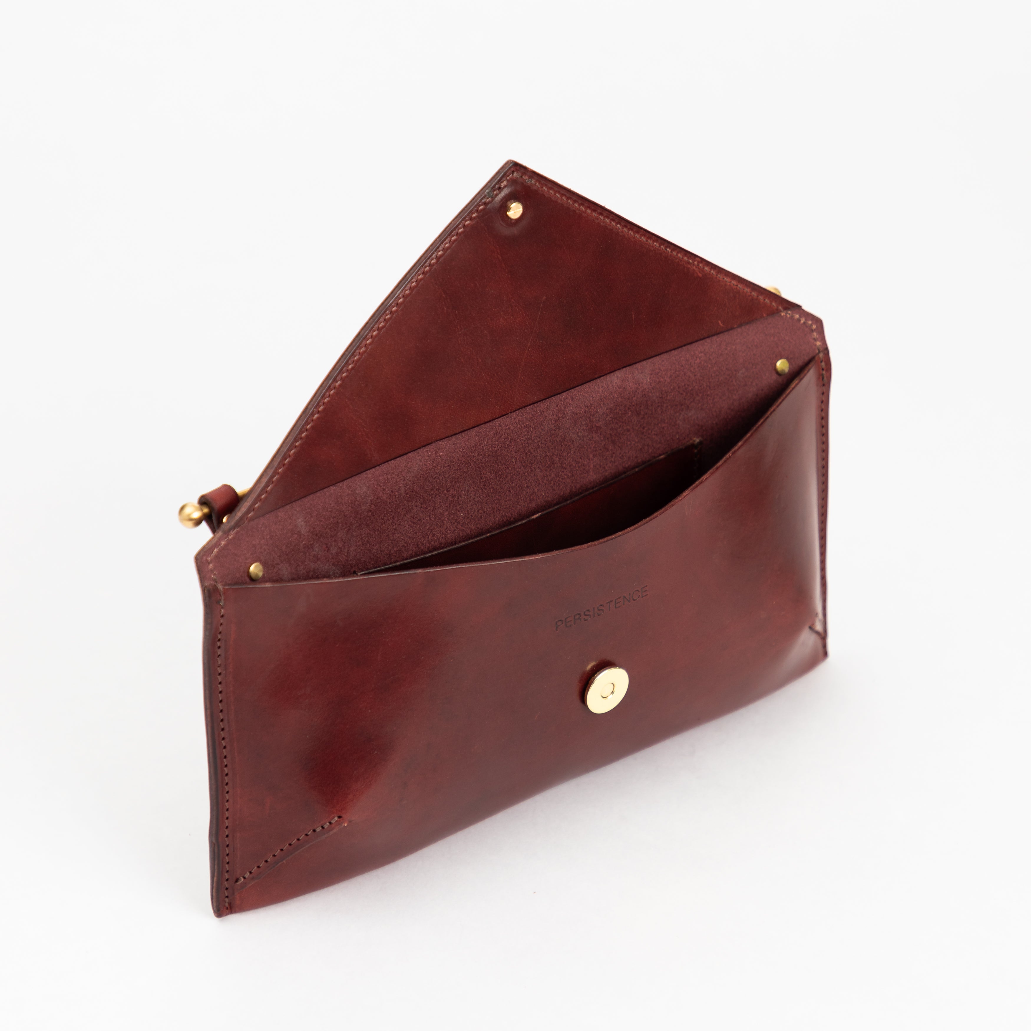 East West Envelope | Oxblood clutch crafted from luxurious full-grain vegetable-tanned leather with gold-tone hardware and interior pocket
