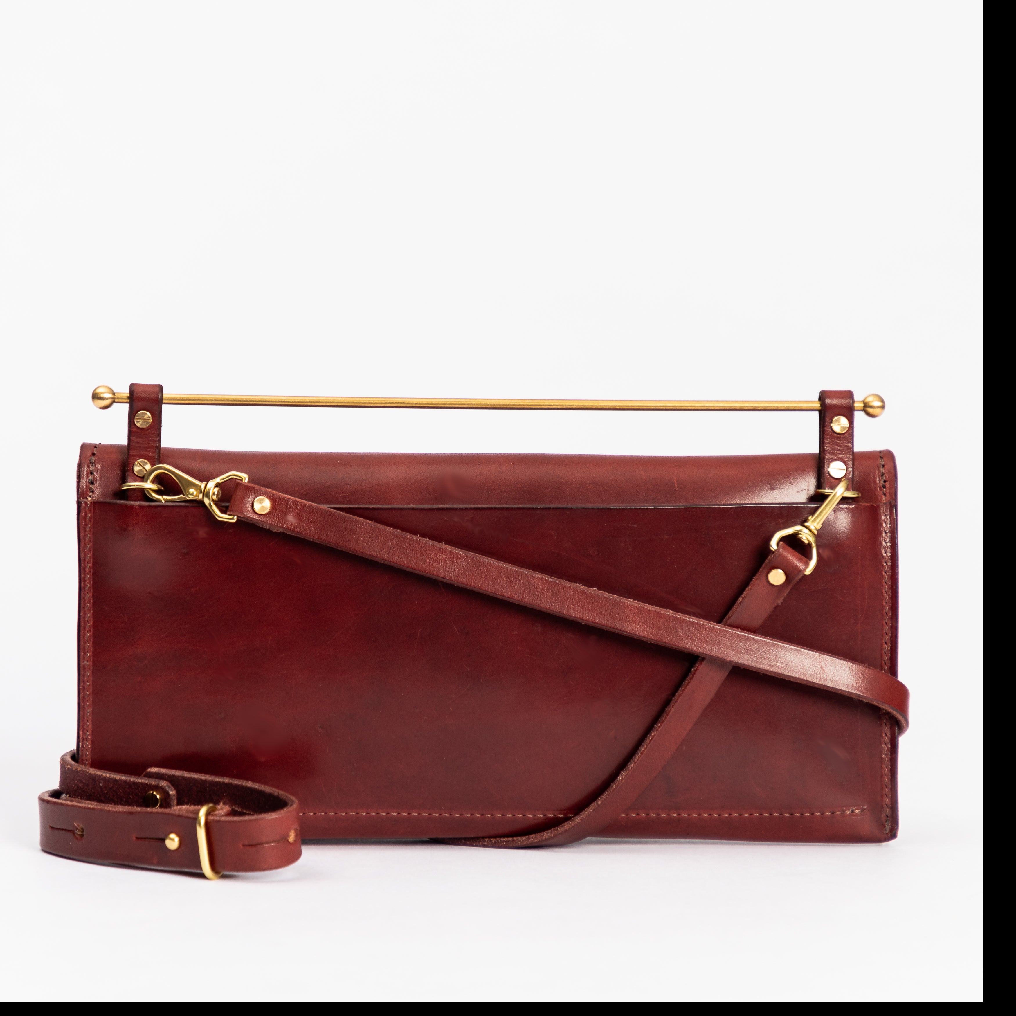 East West Envelope | Oxblood full-grain leather clutch with removable crossbody strap and luxe gold hardware details