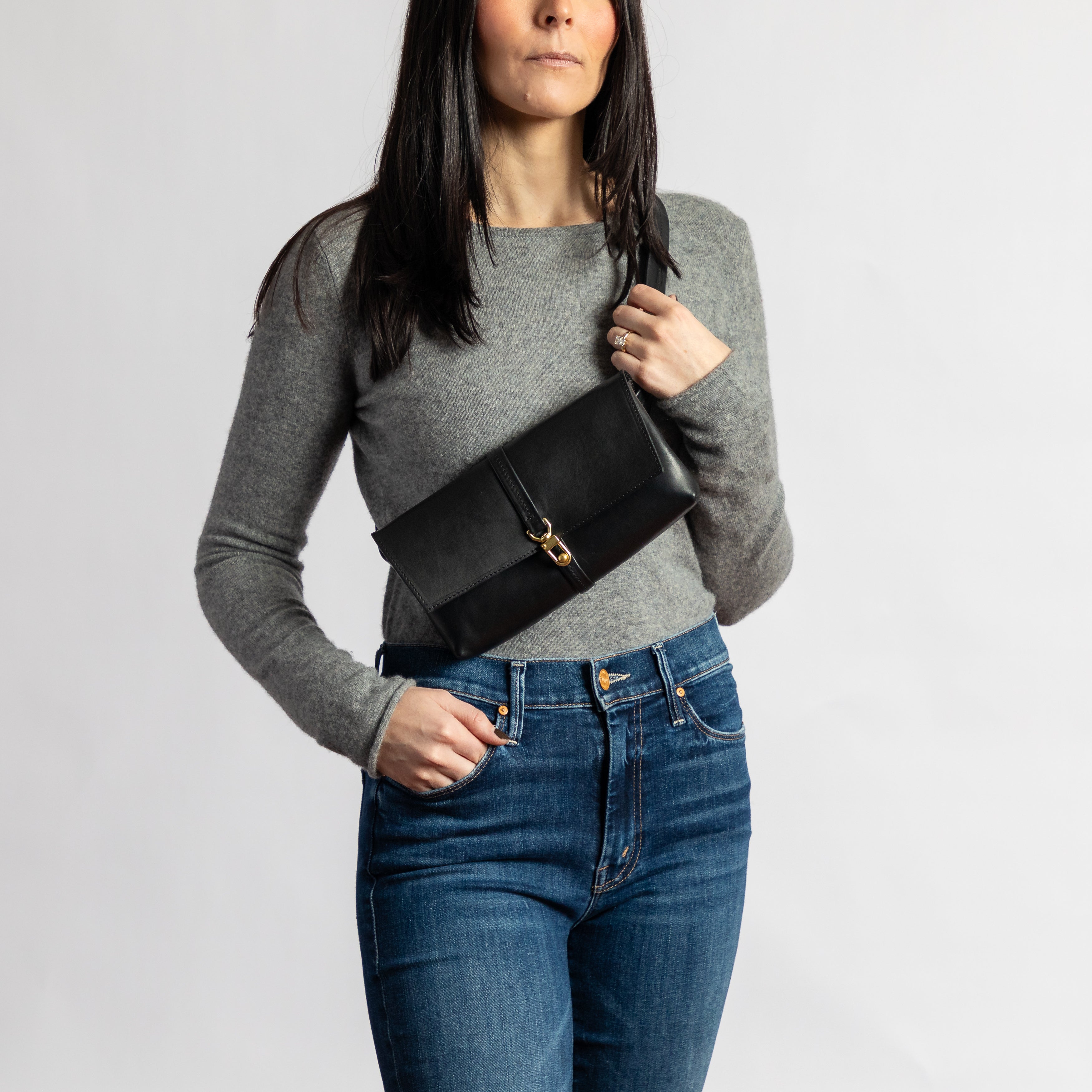 Woman wearing a smooth full-grain leather Festival Bag | Black with gold hardware, styled as a minimalist crossbody accessory