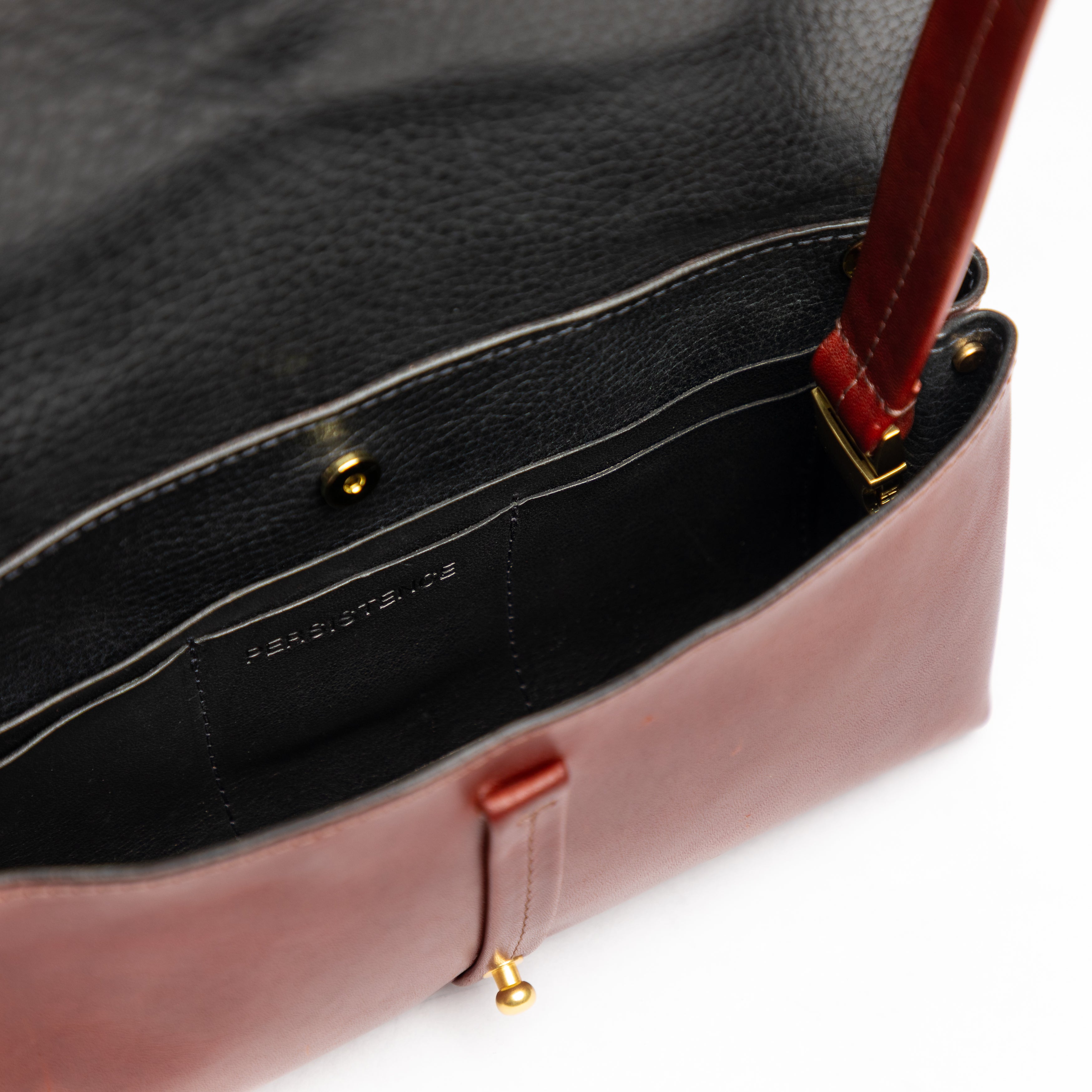 Interior close-up of the luxury leather Festival Bag | Sangria showing smooth full-grain leather and gold hardware detailing