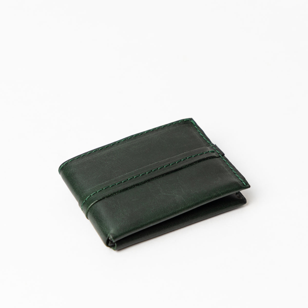Angled closed Deep Forest full-grain leather bifold wallet with a curved card pocket and tonal stitching on white