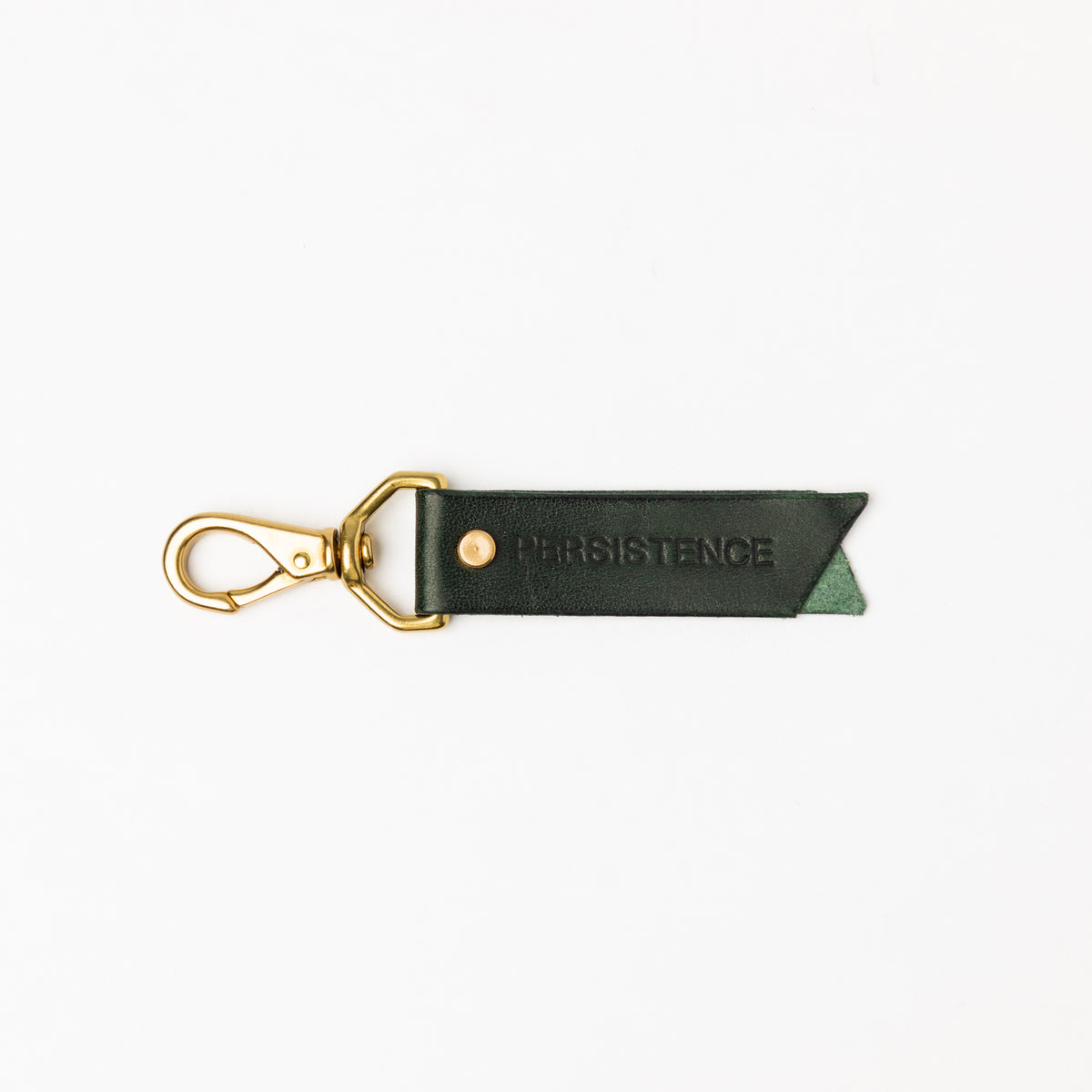 PERSISTENCE debossed dark green leather keychain with a brass swivel clasp and notched ribbon end on white