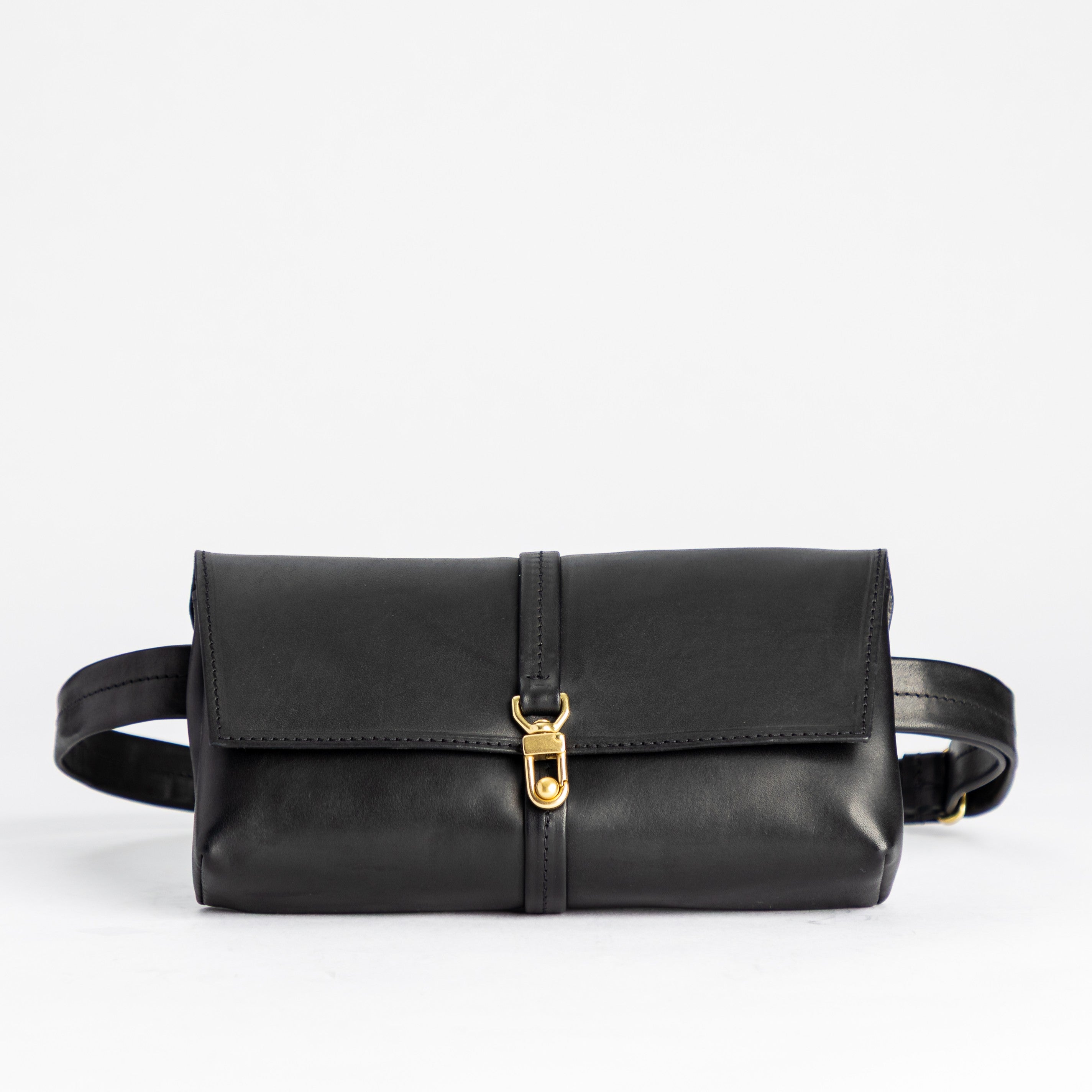 Black leather waist bag with a gold buckle on a white background