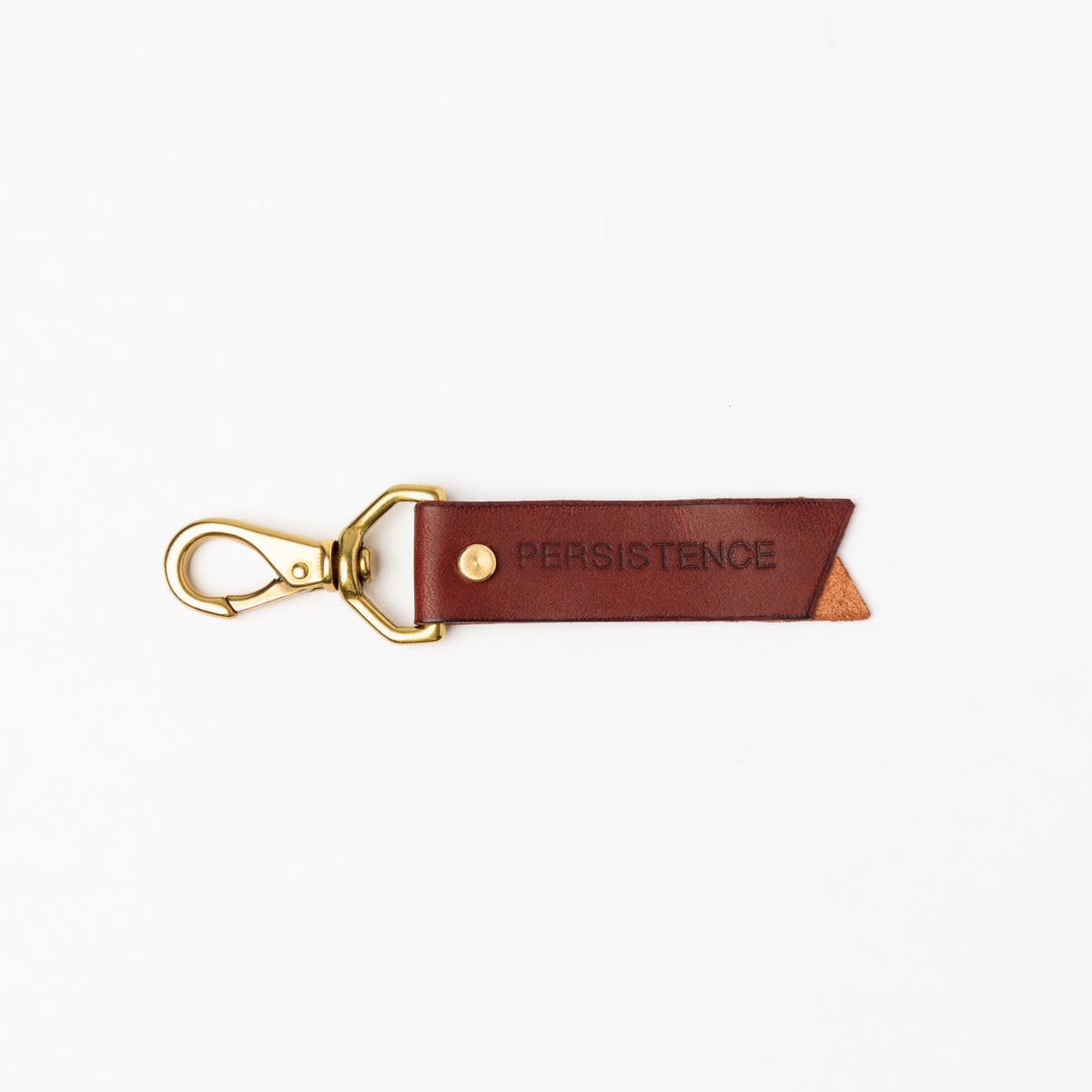 Burgundy full-grain leather keychain, debossed PERSISTENCE with a solid brass swivel clasp and rivet on white